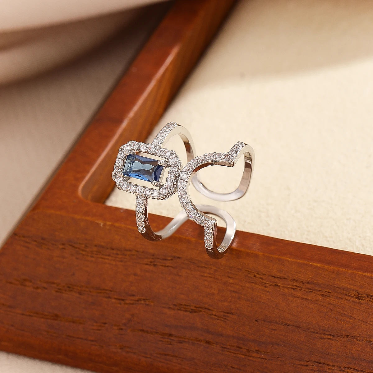 Gold pavé double-band adjustable ring with blue emerald-cut stone