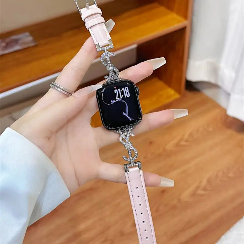“Pink leather Apple Watch band with S-shaped rhinestone connector – flatlay”