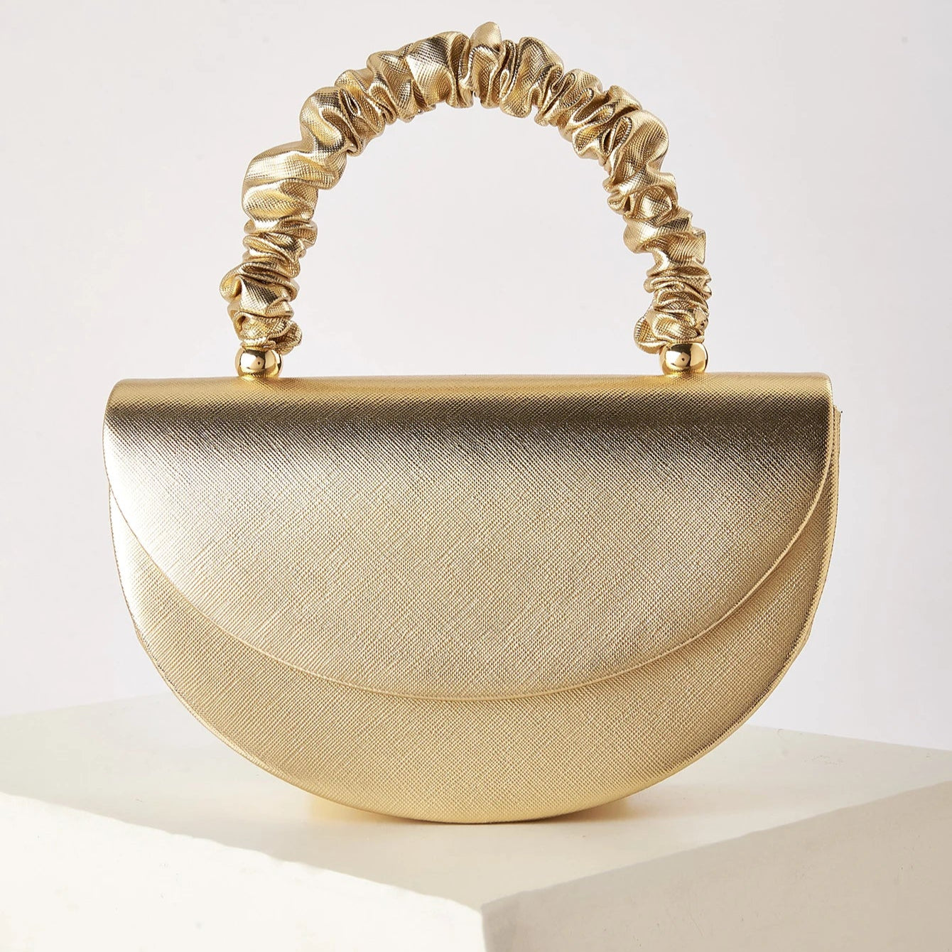 Gold ruched handle half-moon evening clutch, front view