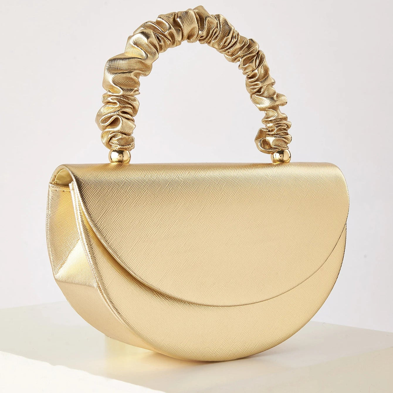 Gold ruched handle half-moon evening clutch, front view