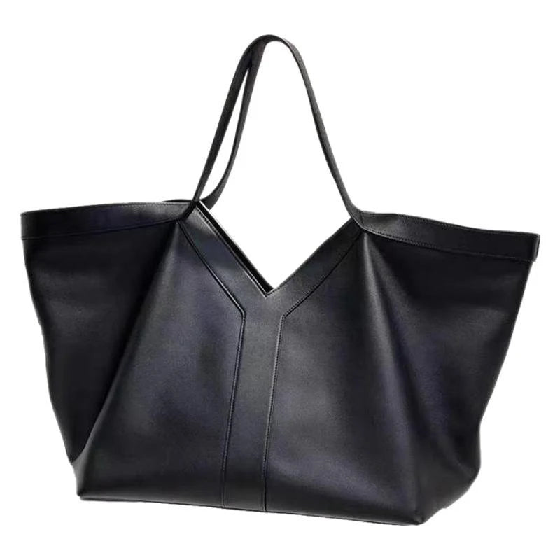 Large black V-cut leather tote bag with double shoulder straps on display