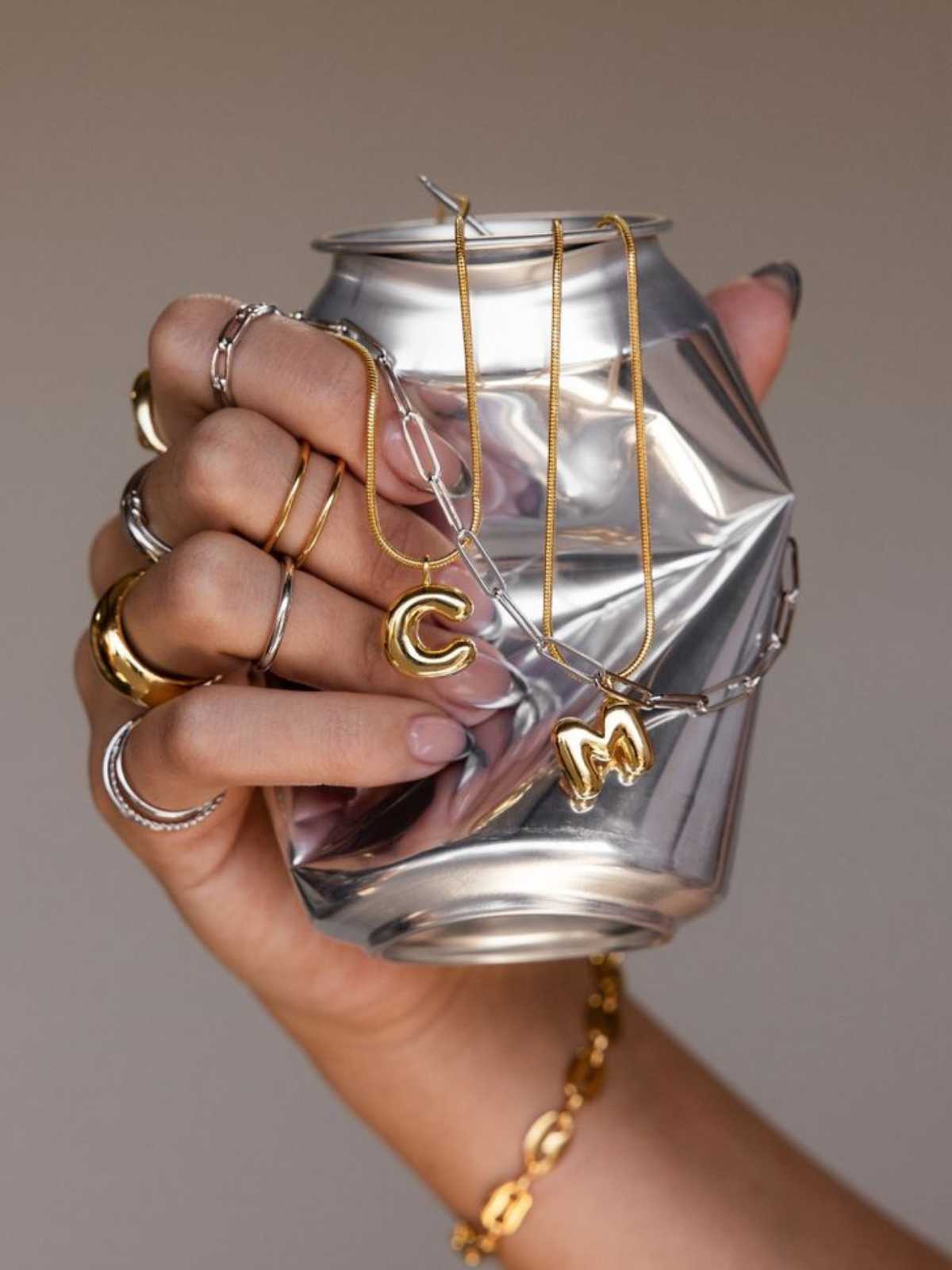 Model wearing Murps gold PVD earrings and bracelets outdoors.