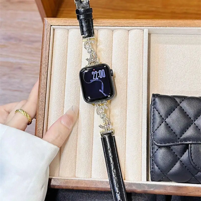 “Black leather Apple Watch band with jeweled S connector – closeup on wrist”