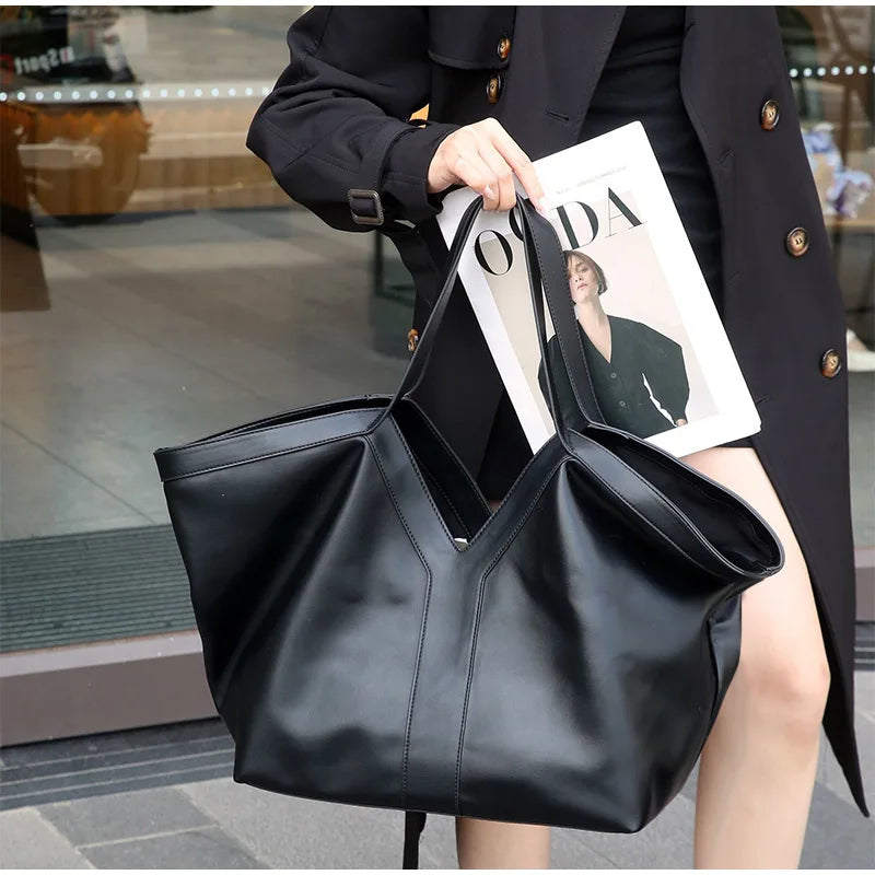Large black V-cut leather tote bag with double shoulder straps on display