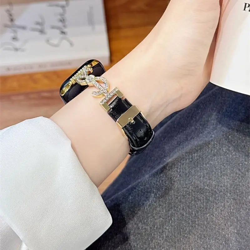 “Black leather Apple Watch band with jeweled S connector – closeup on wrist”