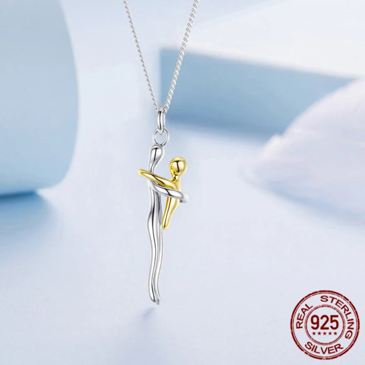 Jewelry pendant with gold and silver design on a light blue background, featuring the brand 'Murps'.