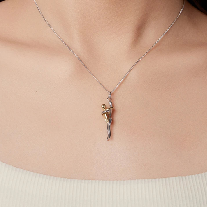 Silver necklace with a pendant on a person's neck, brand 'Murps' visible