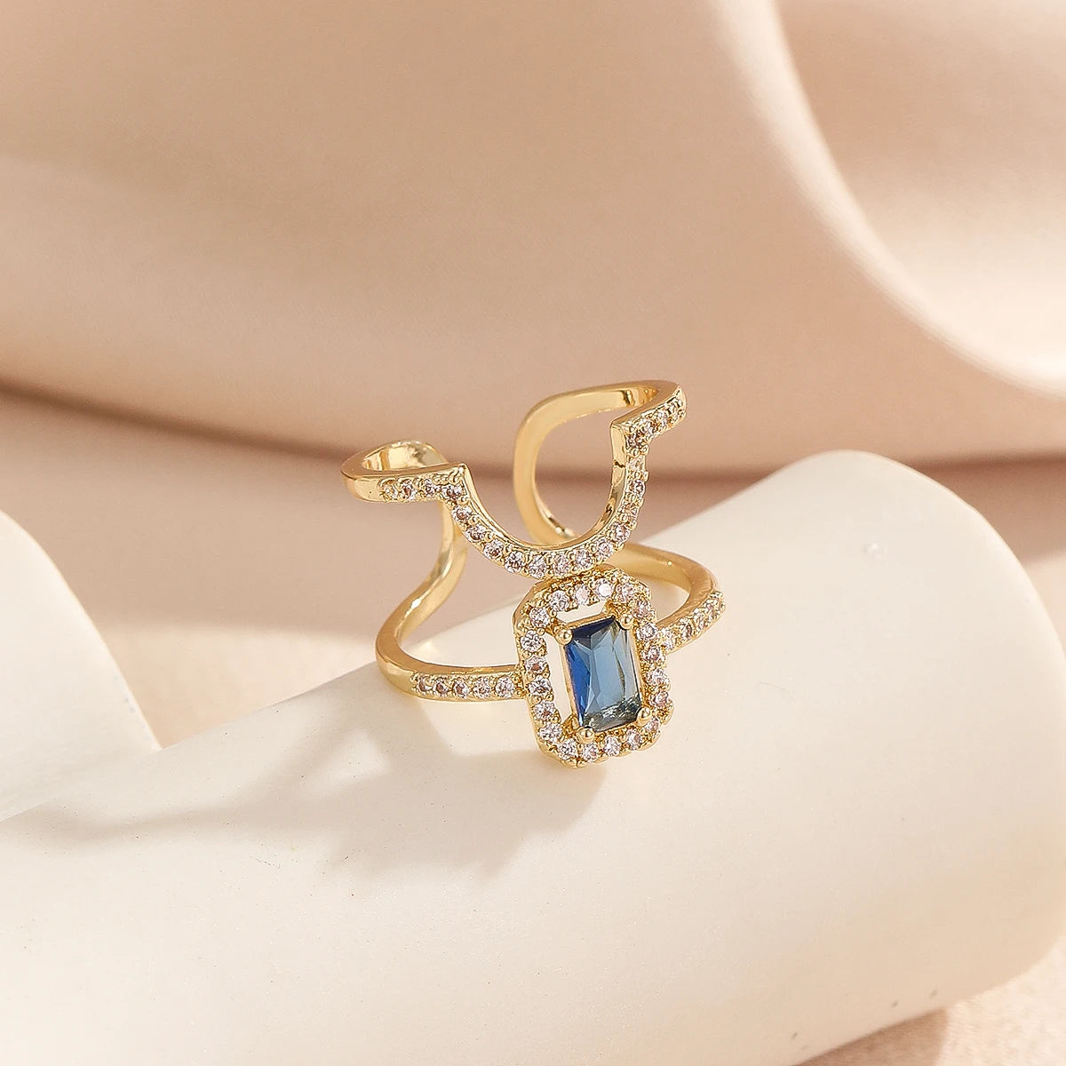 Gold pavé double-band adjustable ring with blue emerald-cut stone
